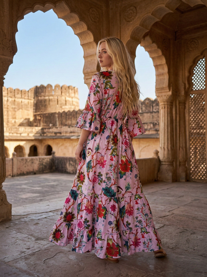 Woman in a floral dress standing in an architectural setting with arches and fortifications.